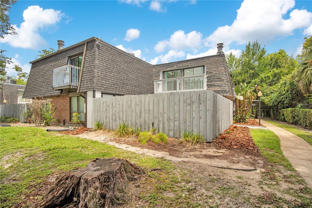 A two-story building with a mansard roof, balconies, and a wooden privacy fence — 2577 DERBYSHIRE CIRCLE, CASSELBERRY, FL