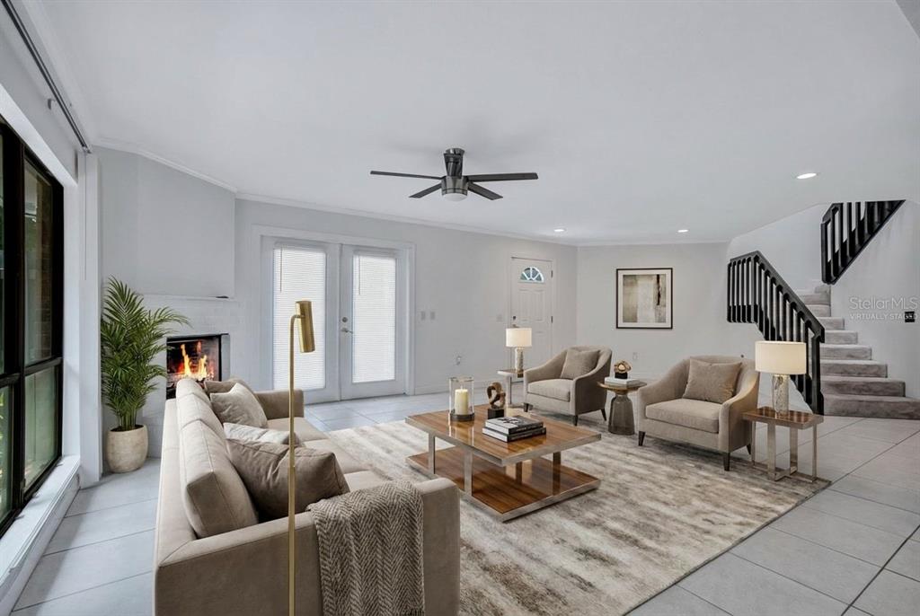 A living room features a fireplace, a staircase, and neutral furniture on a large rug — 2577 DERBYSHIRE CIRCLE, CASSELBERRY, FL