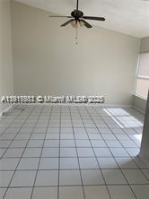 An empty room with white tile flooring, a vaulted ceiling, and a ceiling fan — 1316 White Pine Dr, Wellington FL 33414, WELLINGTON, FL