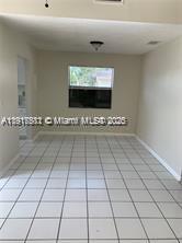 An empty room with light-colored floor tiles, a window, and a ceiling light fixture — 1316 White Pine Dr, Wellington FL 33414, WELLINGTON, FL