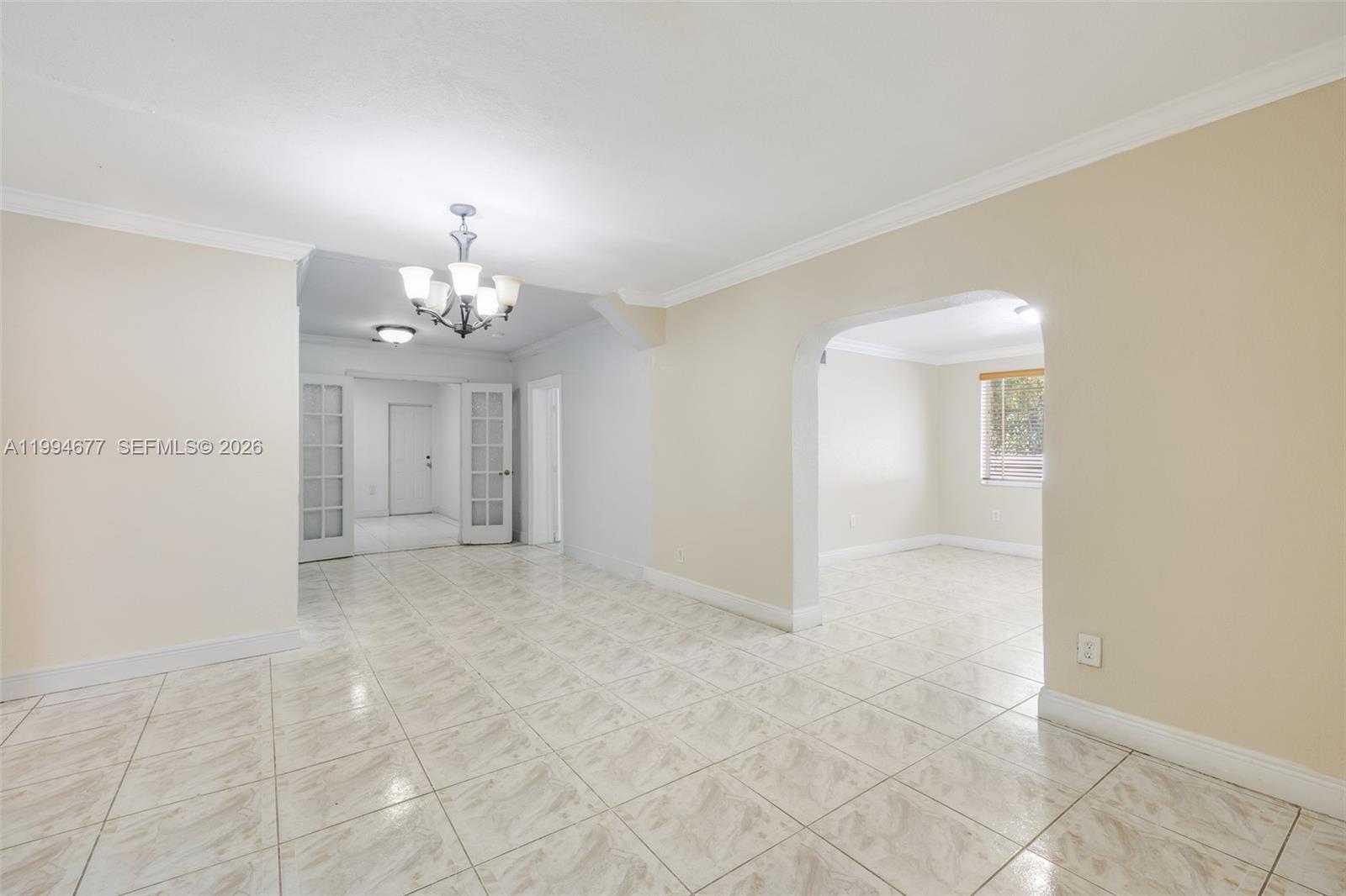An interior room features light-colored tile flooring, an arched entryway, and a hanging chandelier — 674 W 23rd St, Hialeah FL 33010, HIALEAH, FL