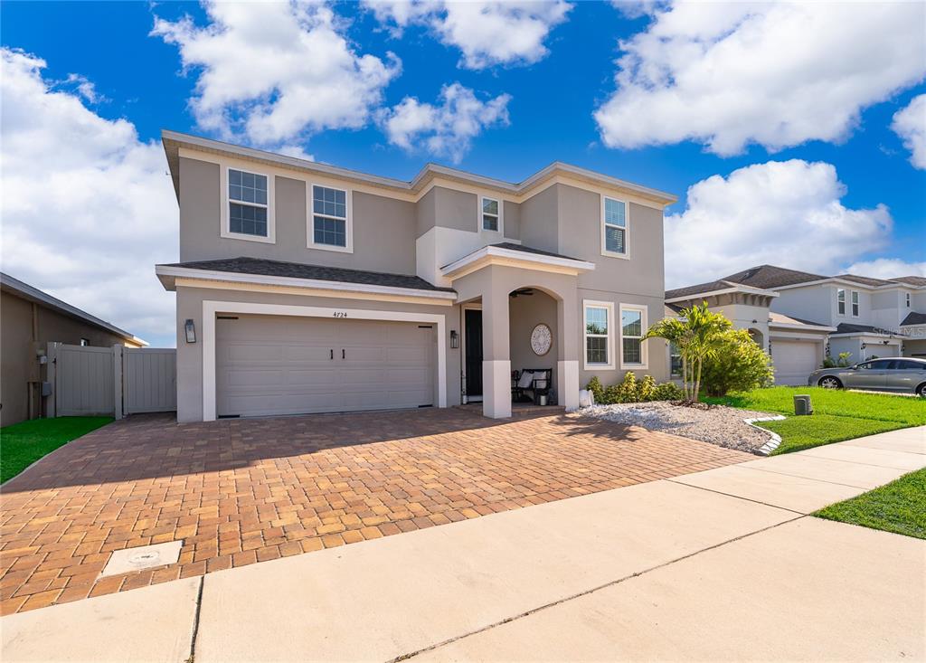 A two-story suburban house with a paved driveway, a two-car garage, and a covered entryway — 4724 MARCOS CIRCLE, KISSIMMEE, FL