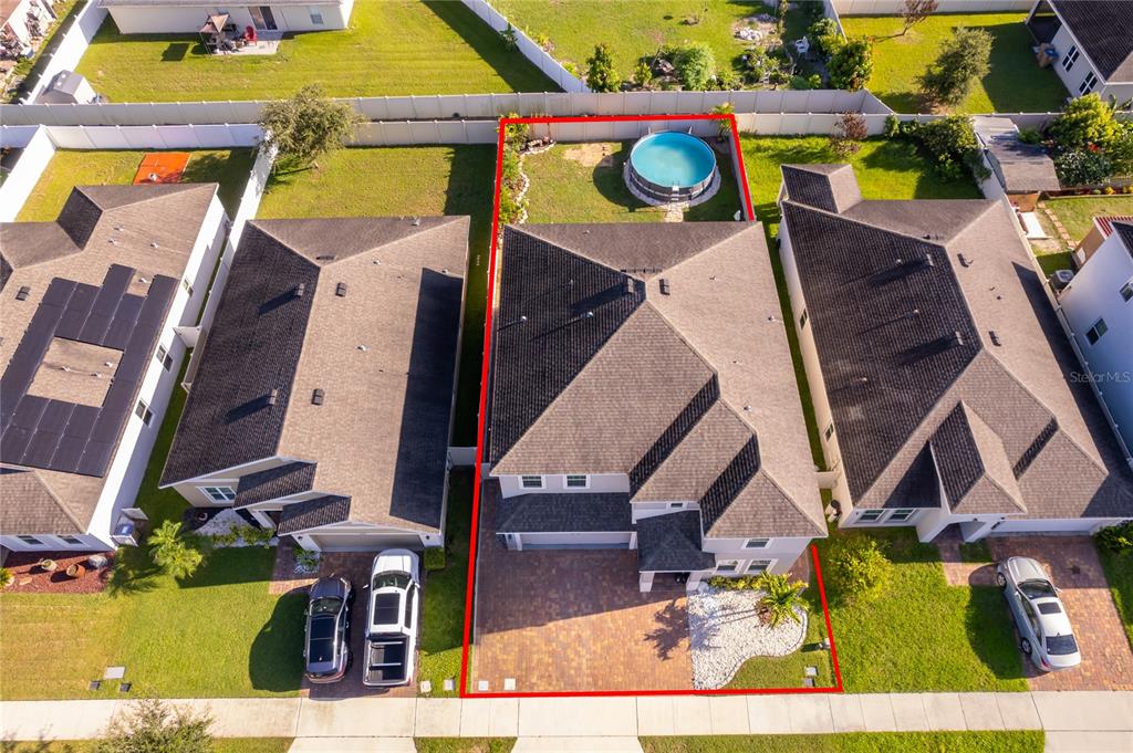 An aerial view shows a two-story house with a backyard pool and paved driveway — 4724 MARCOS CIRCLE, KISSIMMEE, FL