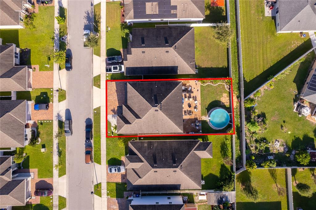 An aerial view shows a residential house with a backyard pool and patio area — 4724 MARCOS CIRCLE, KISSIMMEE, FL