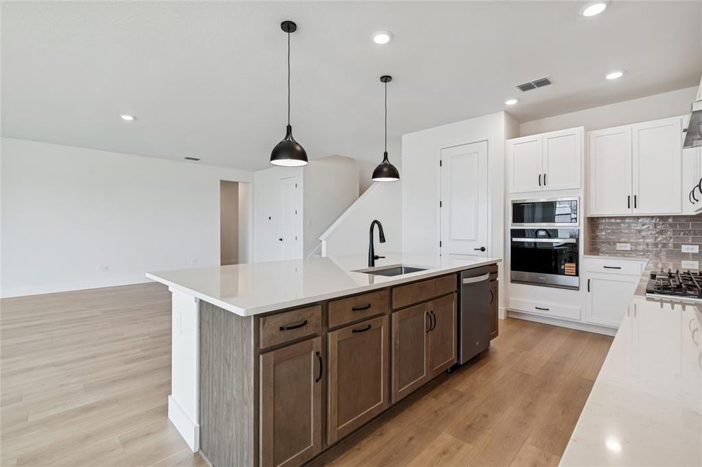 A kitchen features a wooden island with a white countertop, white cabinets, and stainless appliances — 7770 OCEAN SPRAY TRAIL, PALMETTO, FL