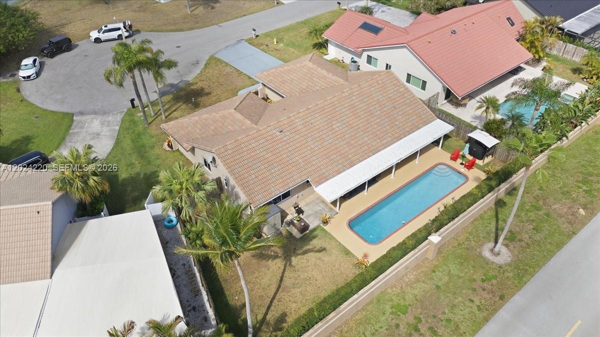 An aerial view shows a house with a tiled roof, a swimming pool, and palm trees — 6520 Olde Moat Way, Davie FL 33331, DAVIE, FL