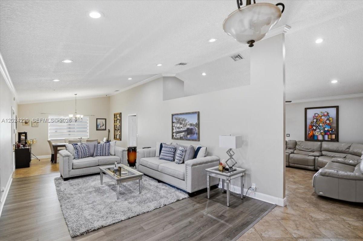 A living room features light gray sofas, a shaggy area rug, and tile flooring — 6520 Olde Moat Way, Davie FL 33331, DAVIE, FL
