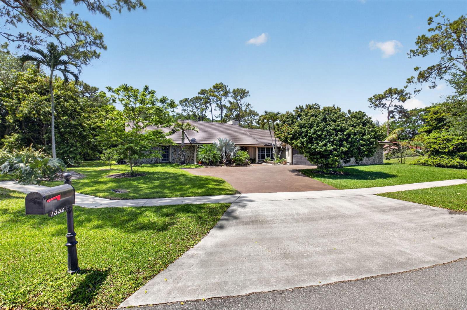 A single-story house with a stone facade, a brown roof, and a large paved driveway — 7332 Estrella Court, Boca Raton FL 33433, BOCA RATON, FL