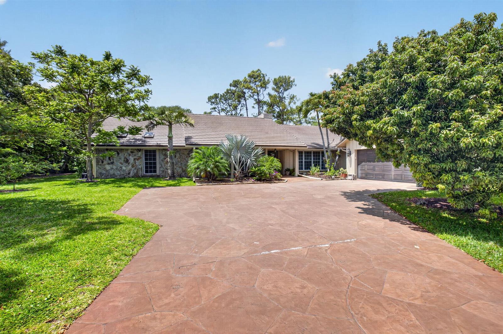 A single-story house with a stone facade, a tiled roof, and a large paved driveway — 7332 Estrella Court, Boca Raton FL 33433, BOCA RATON, FL