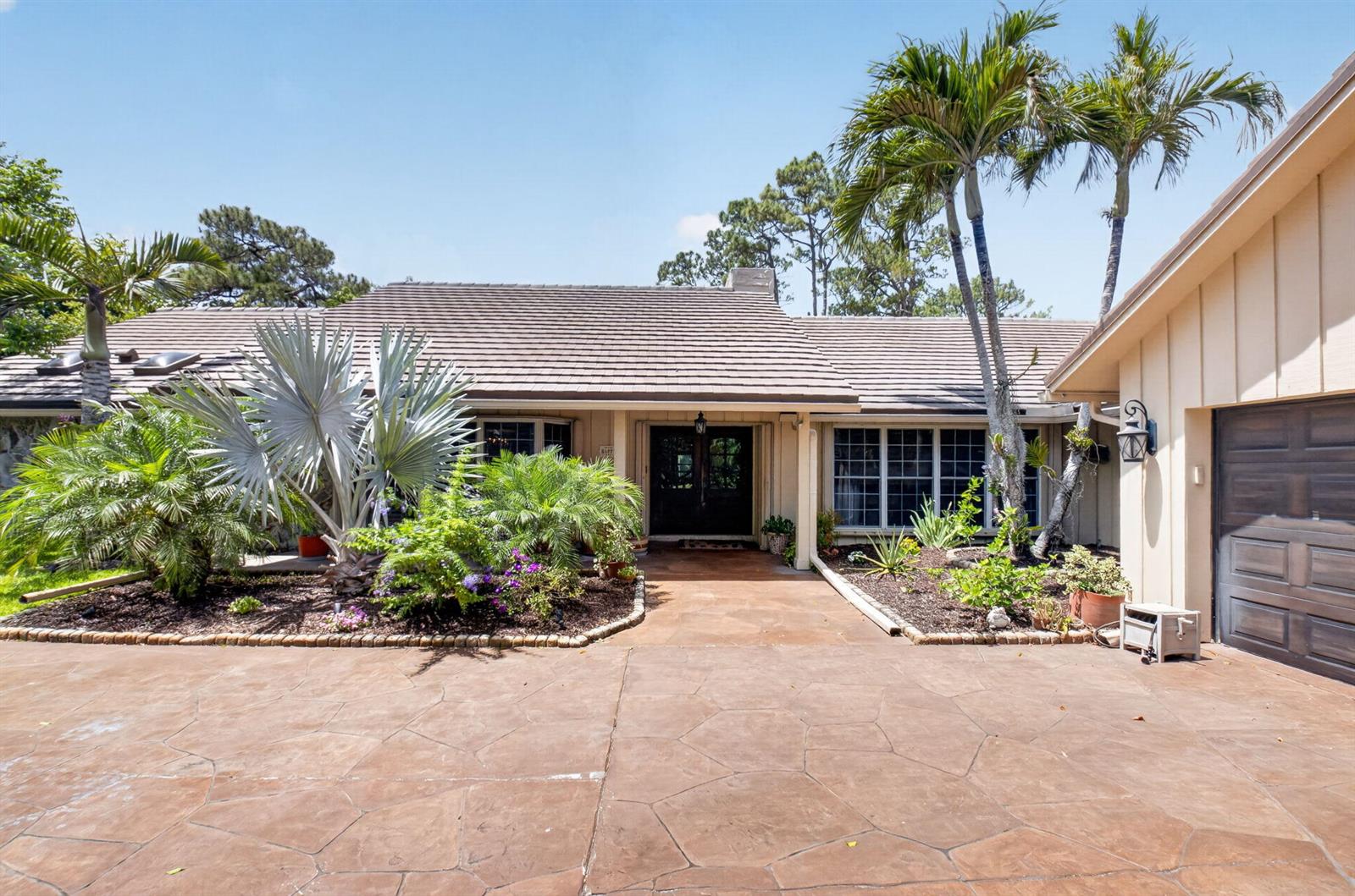 A single-story house with a brown tile roof, palm trees, and a stamped concrete driveway — 7332 Estrella Court, Boca Raton FL 33433, BOCA RATON, FL