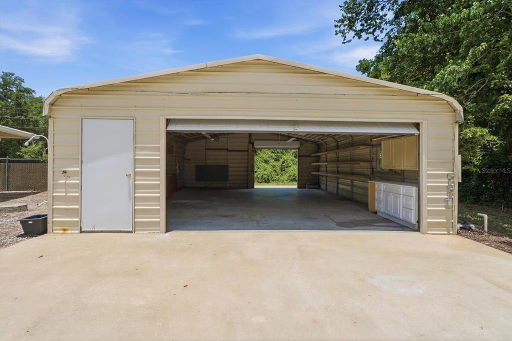 A detached metal garage with a concrete driveway, a side door, and an open bay — 5383 N CARL G ROSE HIGHWAY, HERNANDO, FL