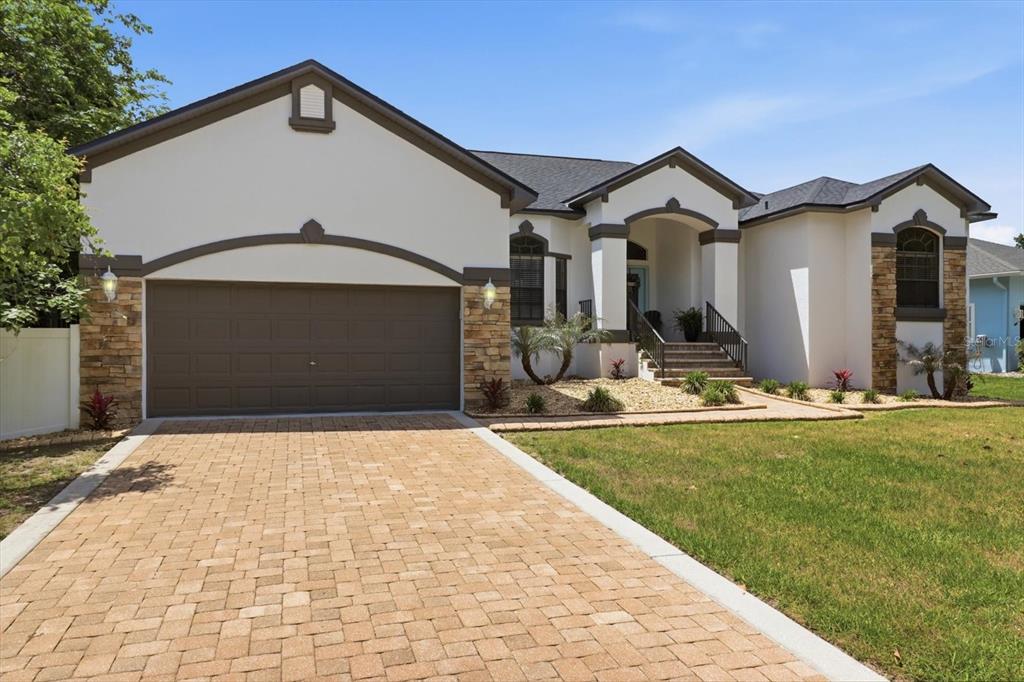 A single-story house with a paved driveway, stone accents, and a covered front entryway — 11870 W WATERWAY DRIVE, HOMOSASSA, FL