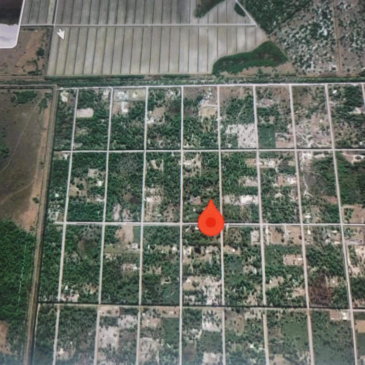An aerial view of a grid-patterned rural landscape featuring a red location pin — 725 S Willow Street, Clewiston FL 33440, CLEWISTON, FL
