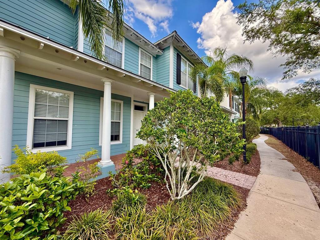 A blue two-story townhouse with a covered porch, white columns, and a sidewalk — 5405 CAFREY PLACE, APOLLO BEACH, FL