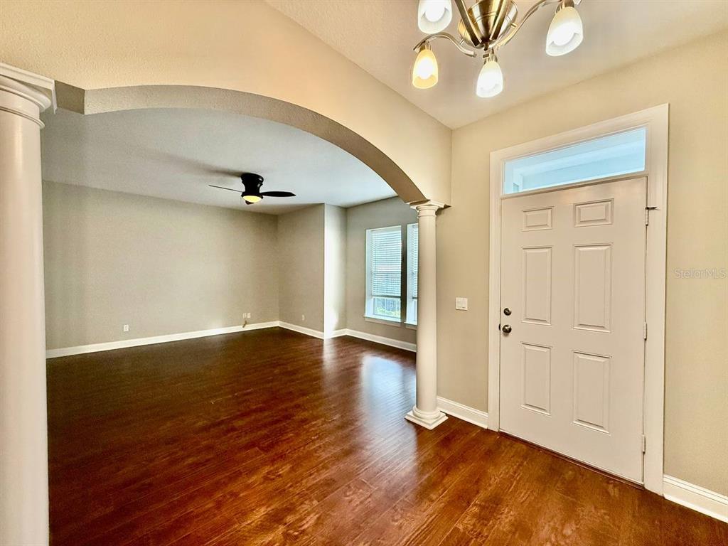 An entryway with a white front door leads into a living room with arched openings — 5405 CAFREY PLACE, APOLLO BEACH, FL