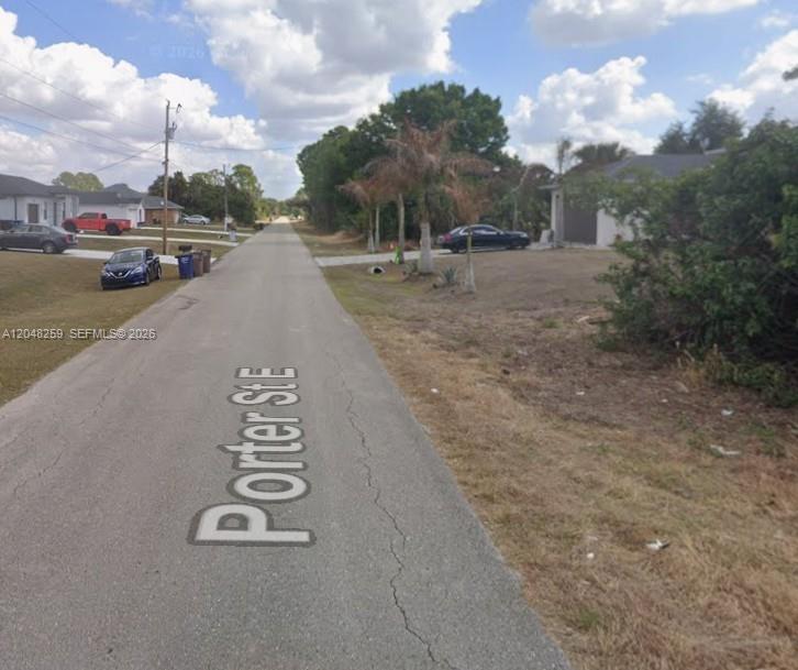 A paved residential street named Porter St E with houses and parked cars on both sides — 820 Porter ST E, Lehigh Acres FL 33974, LEHIGH ACRES, FL