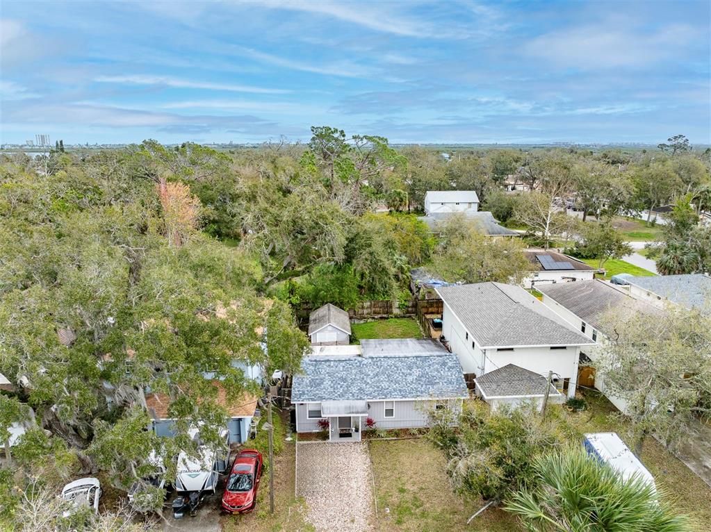 An aerial view shows a single-story house with a gravel driveway and surrounding trees — 5125 ISABELLE AVENUE, PORT ORANGE, FL