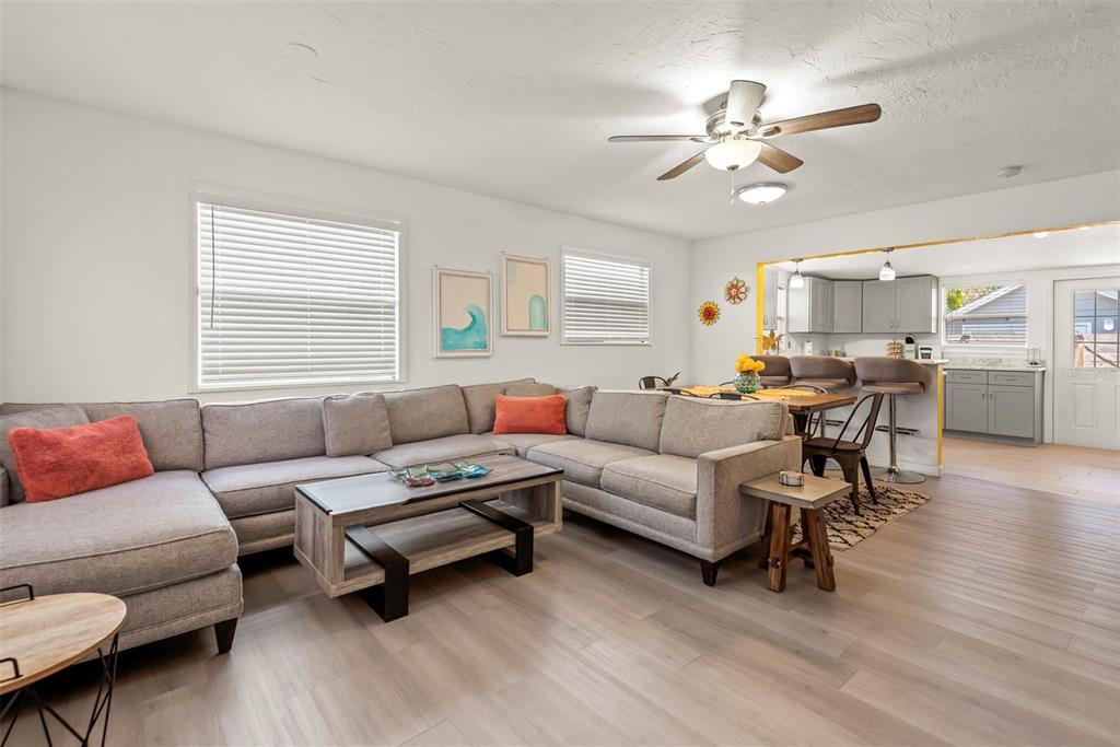 A living room with a gray sectional sofa, coffee table, and an adjacent open kitchen — 5125 ISABELLE AVENUE, PORT ORANGE, FL