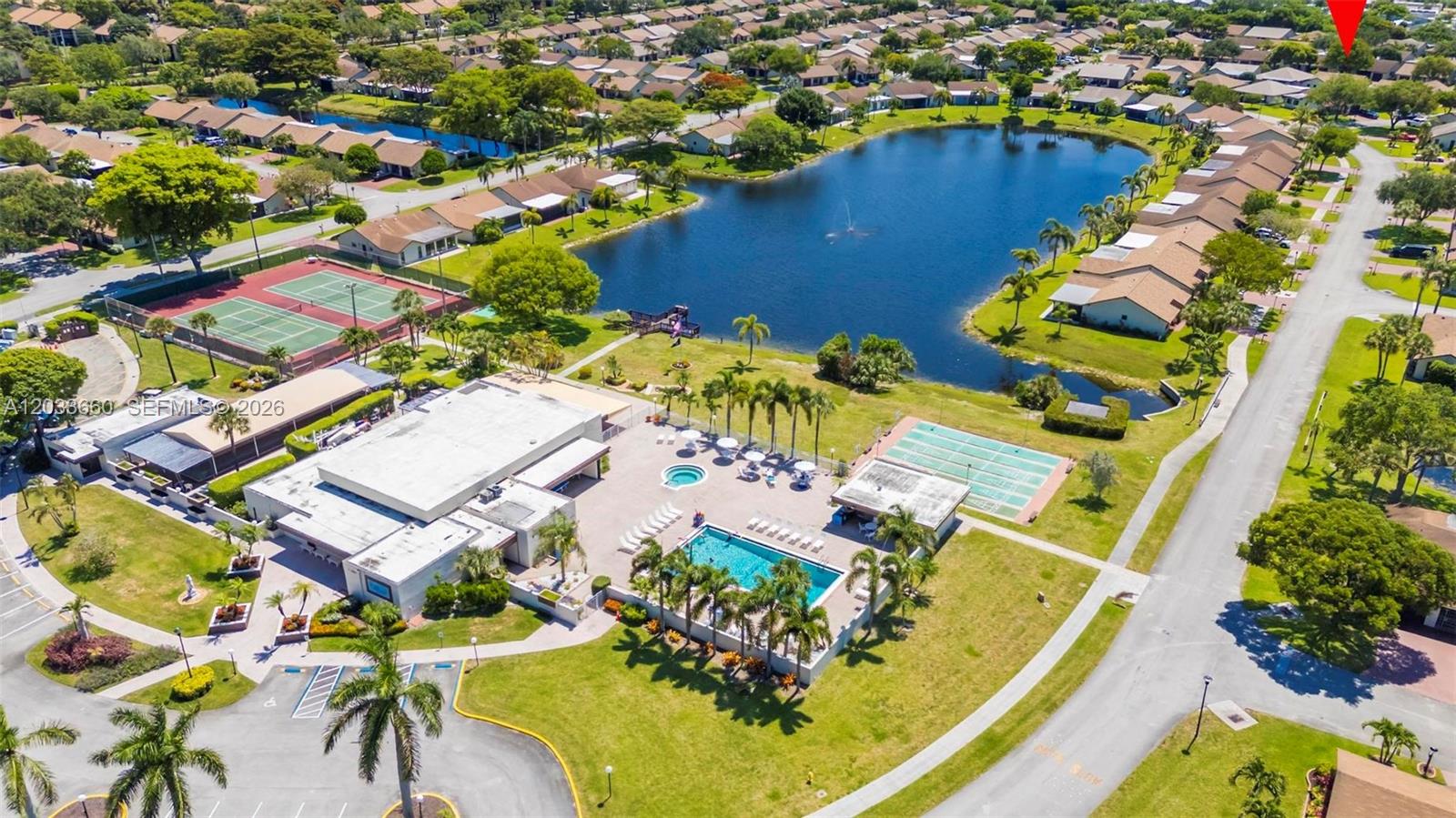 An aerial view shows a community clubhouse with a pool, tennis courts, and a lake — 1726 SW 20th Ter, Deerfield Beach FL 33442, DEERFIELD BEACH, FL