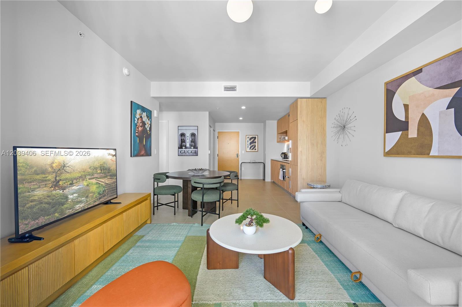 A living room features a white sofa, a round coffee table, and a dining area — 11 NE 6th St # 2411, Miami FL 33132, MIAMI, FL
