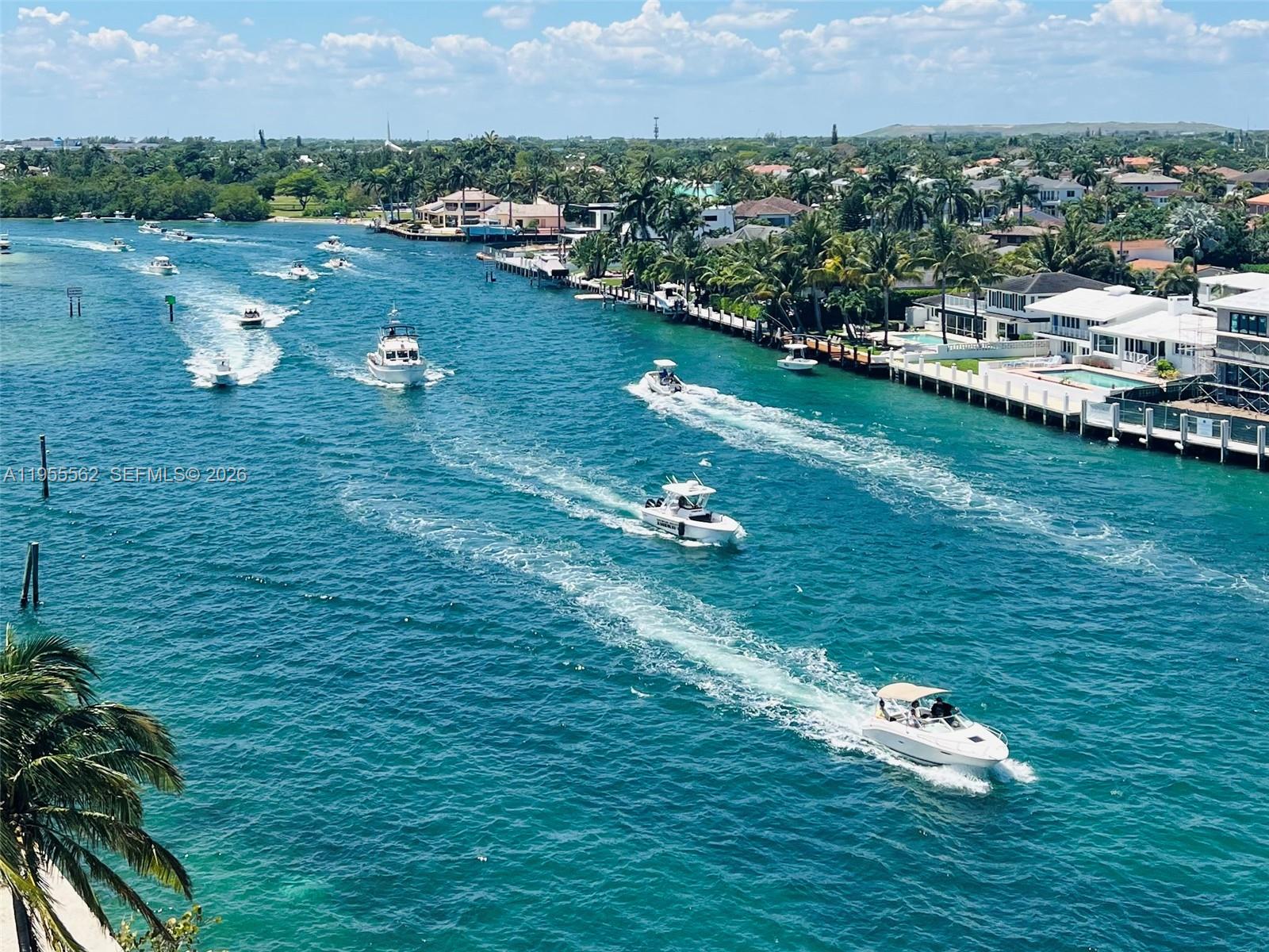 An aerial view shows multiple boats traveling along a canal lined with waterfront homes — 2639 N Riverside Dr # 806, Pompano Beach FL 33062, POMPANO BEACH, FL