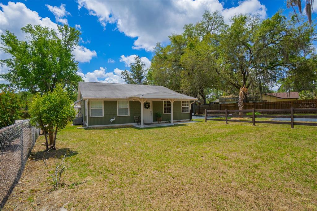 A single-story house with green siding and a covered porch sits in a grassy yard — 4556 E SHOREWOOD DRIVE, HERNANDO, FL
