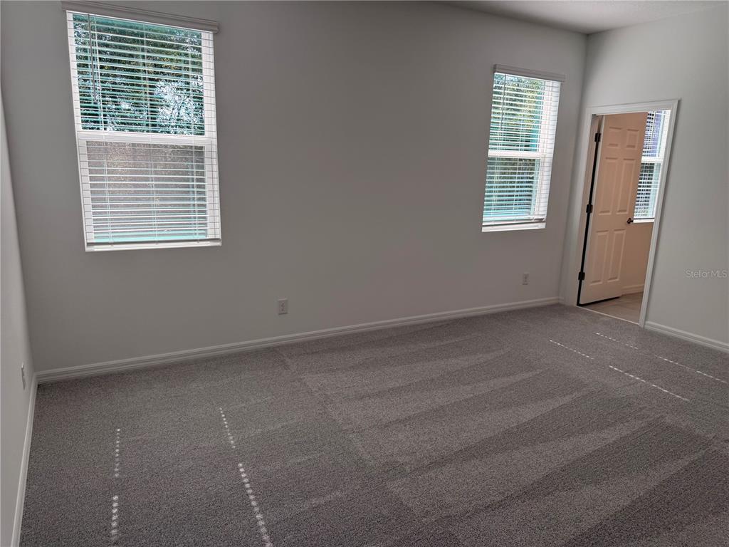 A modern kitchen features white cabinets, a central island, and tile flooring with patio access — 744 FARFIELDS STREET, DELAND, FL