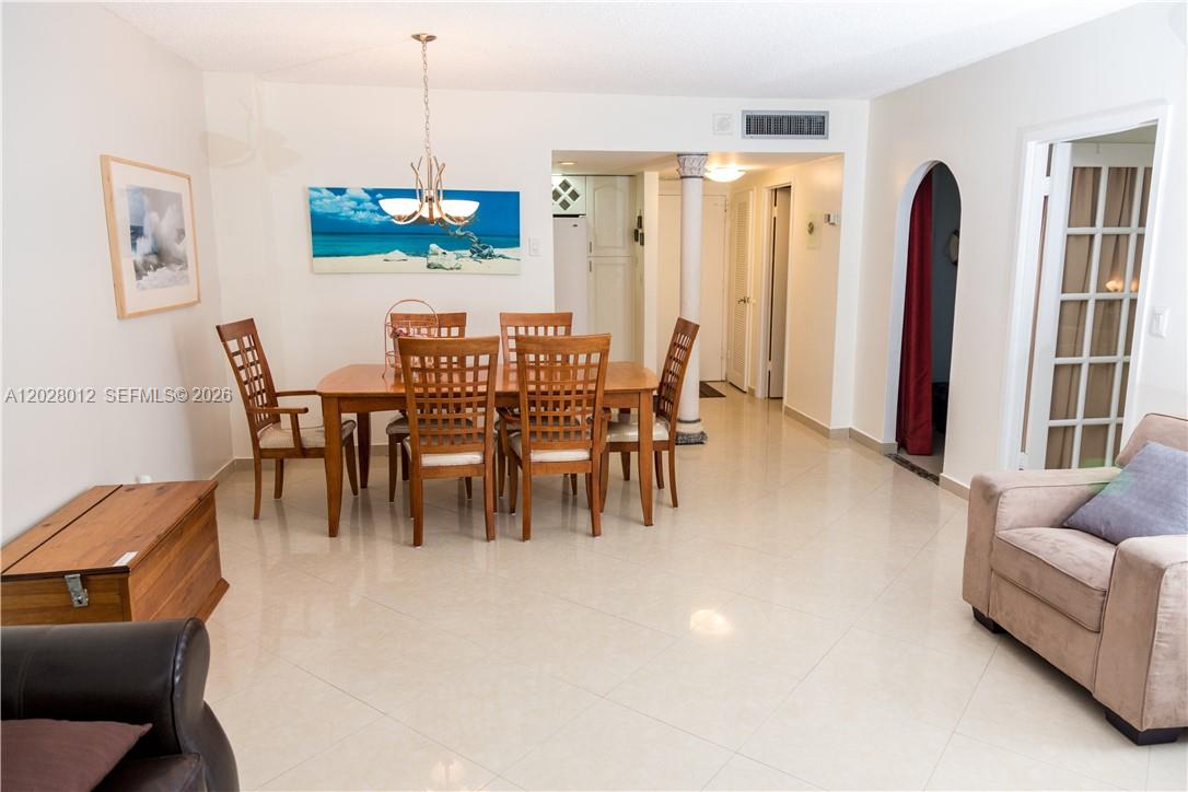A dining area with a wooden table and chairs sits on light tile flooring — 3725 S Ocean Dr # 1003, Hollywood FL 33019, HOLLYWOOD, FL
