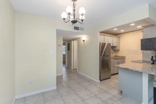A kitchen with stainless steel appliances, light-colored cabinets, and a granite countertop island — 359 S MCMULLEN BOOTH ROAD UNIT 122, CLEARWATER, FL