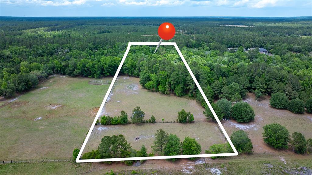 An aerial view shows a large, grassy, partially wooded plot of land outlined in white — 6967 SHARRON ROAD, GREEN COVE SPRINGS, FL