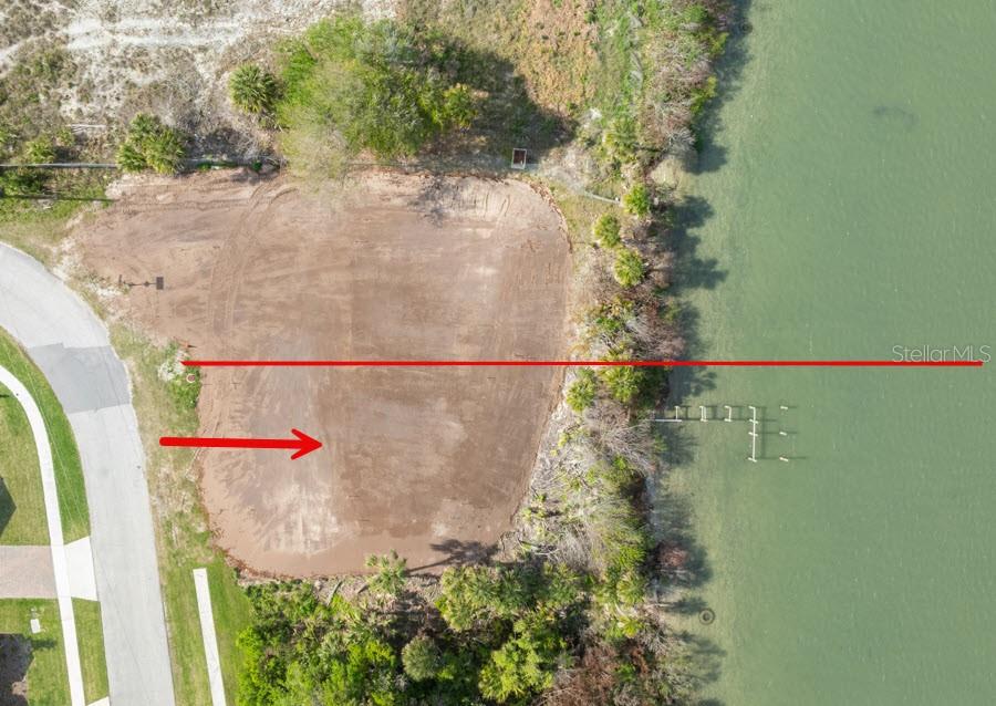 An aerial view shows a cleared, vacant waterfront lot next to a paved road — 185 JONES FISH CAMP ROAD, EDGEWATER, FL