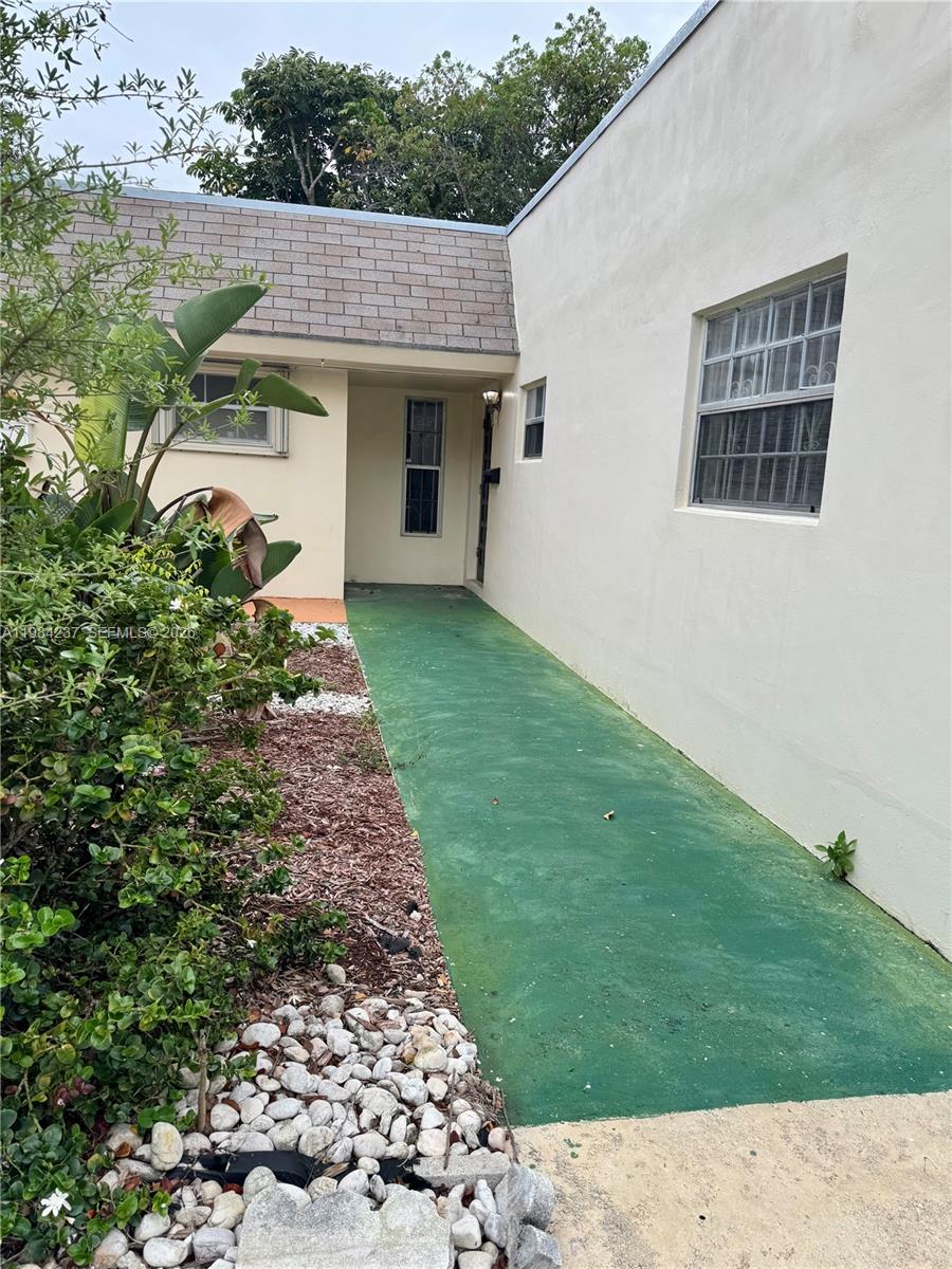 A green walkway leads to the recessed entrance of a house with white exterior walls — 11234 SW 169th St # V3443, Miami FL 33157, MIAMI, FL