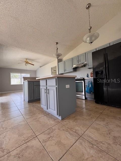 A kitchen features a central island, grey cabinetry, tile flooring, and a black refrigerator — 2405 LINCOLNSHIRE COURT, KISSIMMEE, FL