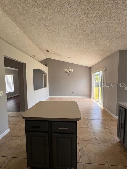 A kitchen island sits in the foreground of an open-concept dining area with tile floors — 2405 LINCOLNSHIRE COURT, KISSIMMEE, FL