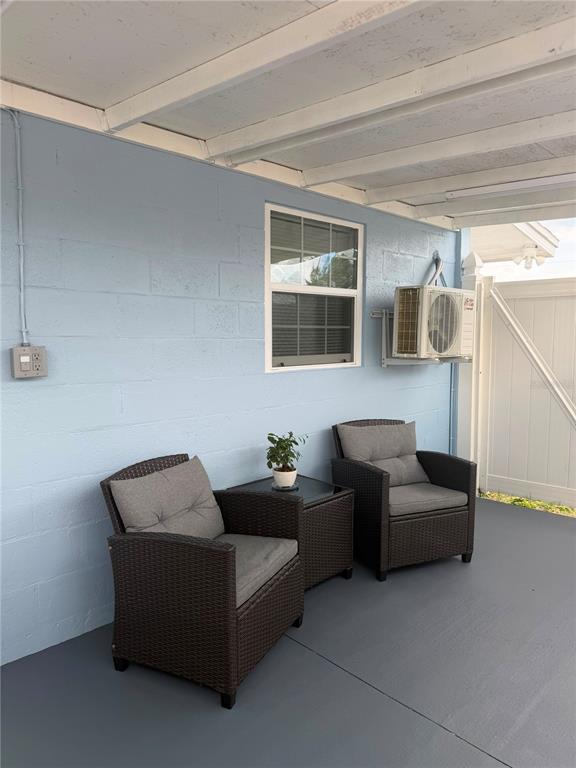 A covered patio features a light blue concrete block wall, two wicker chairs, and an AC unit — 4514 W FERN STREET, TAMPA, FL