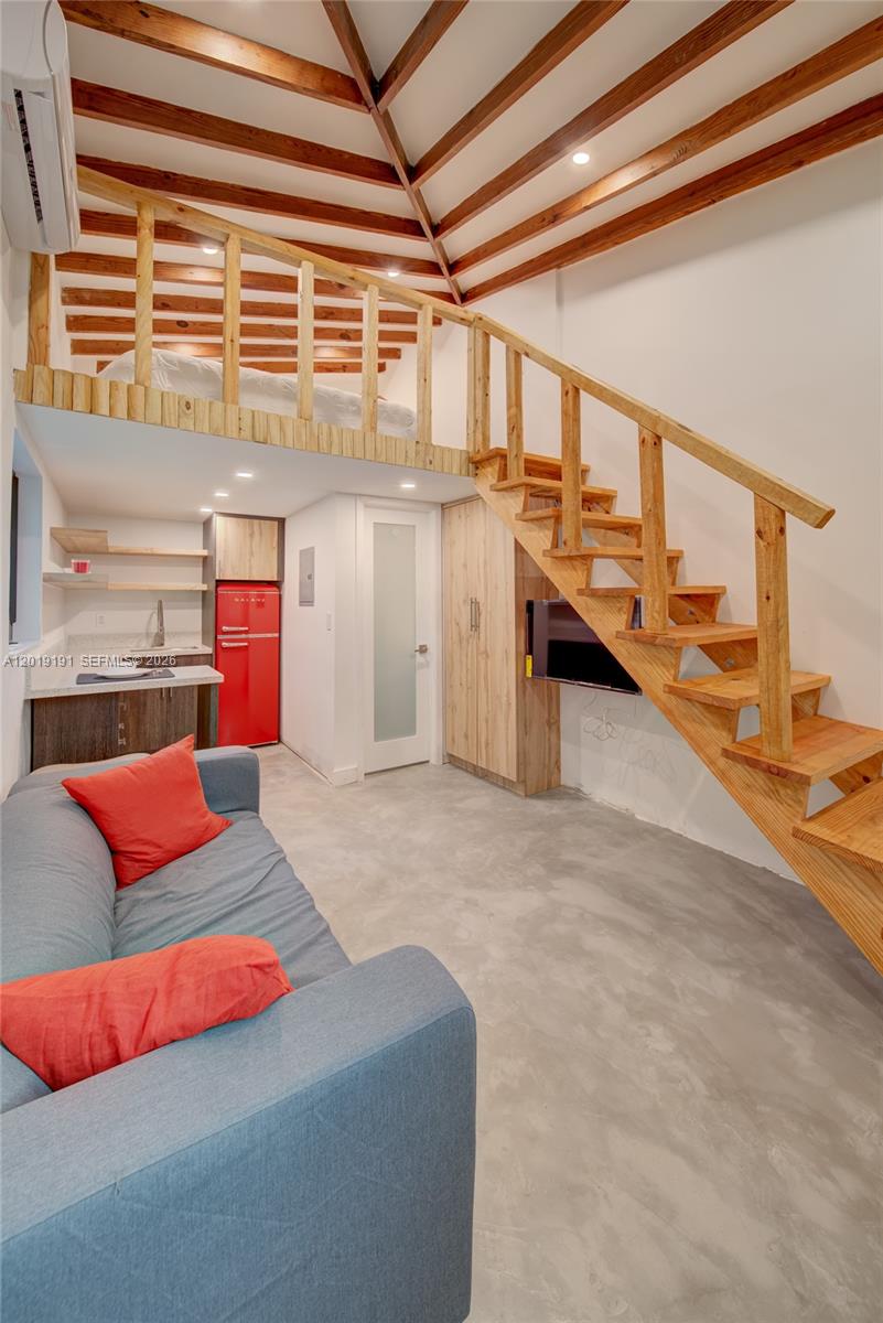 A small living area features a loft bedroom, wooden stairs, and a red refrigerator — 6631 Tamiami Canal Rd, Miami FL 33126, MIAMI, FL
