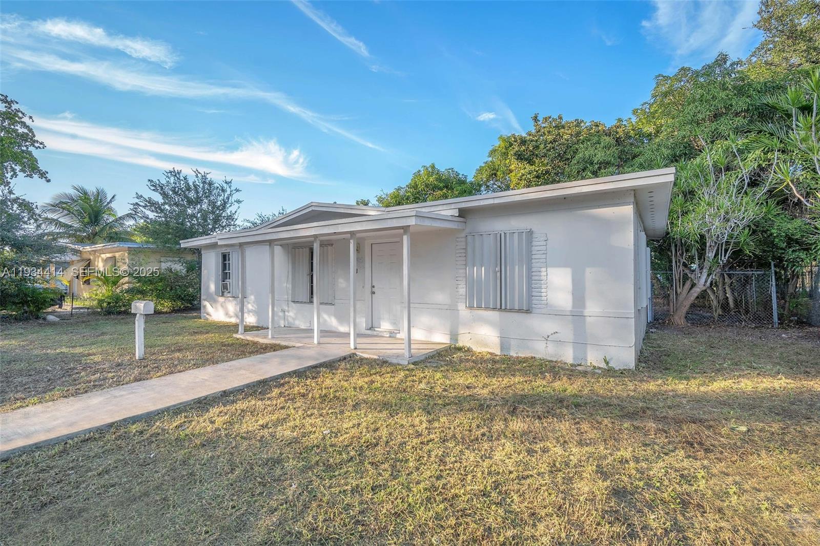 A single-story white house with a front porch and metal hurricane shutters — 265 NW 135th, North Miami FL 33168, NORTH MIAMI, FL