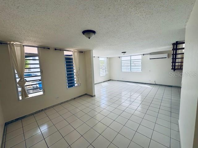 An open living area features white tile flooring, a staircase, and a glass-paneled front door — 70 VIA PLAYERA, TOA BAJA, PR
