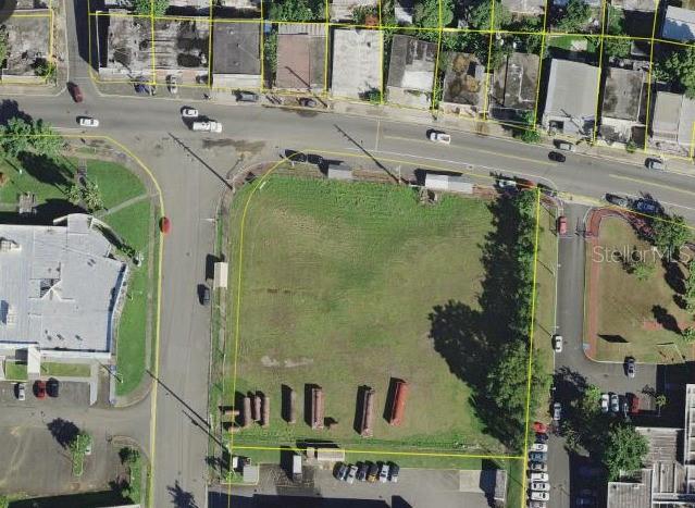An aerial view shows a vacant, rectangular grass lot bordered by streets and nearby buildings — 865 KM 4.8 UNIT 1, TOA BAJA, PR