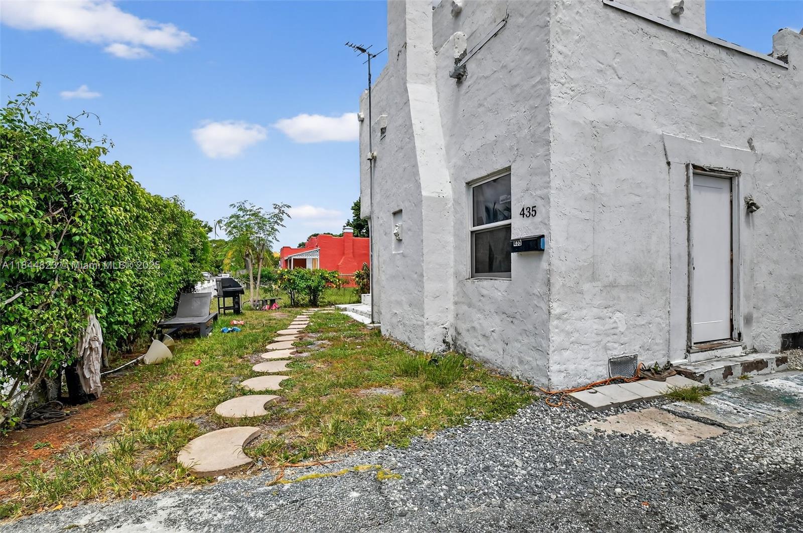 A white stucco building with a stone path leading through a grassy yard — 435 Avenida Alegre, West Palm Beach FL 33405, WEST PALM BEACH, FL