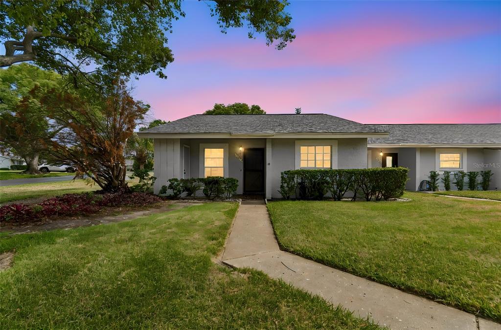 A single-story gray house with a walkway and lawn under a colorful sunset sky — 7725 DANUBE DRIVE UNIT 0000, HUDSON, FL