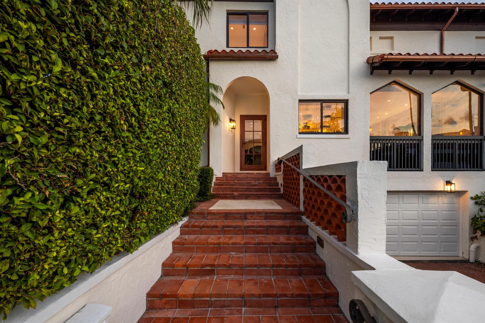 A set of red brick stairs leads to the arched front entrance of a white house — 260 Everglade Avenue, Palm Beach FL 33480, PALM BEACH, FL