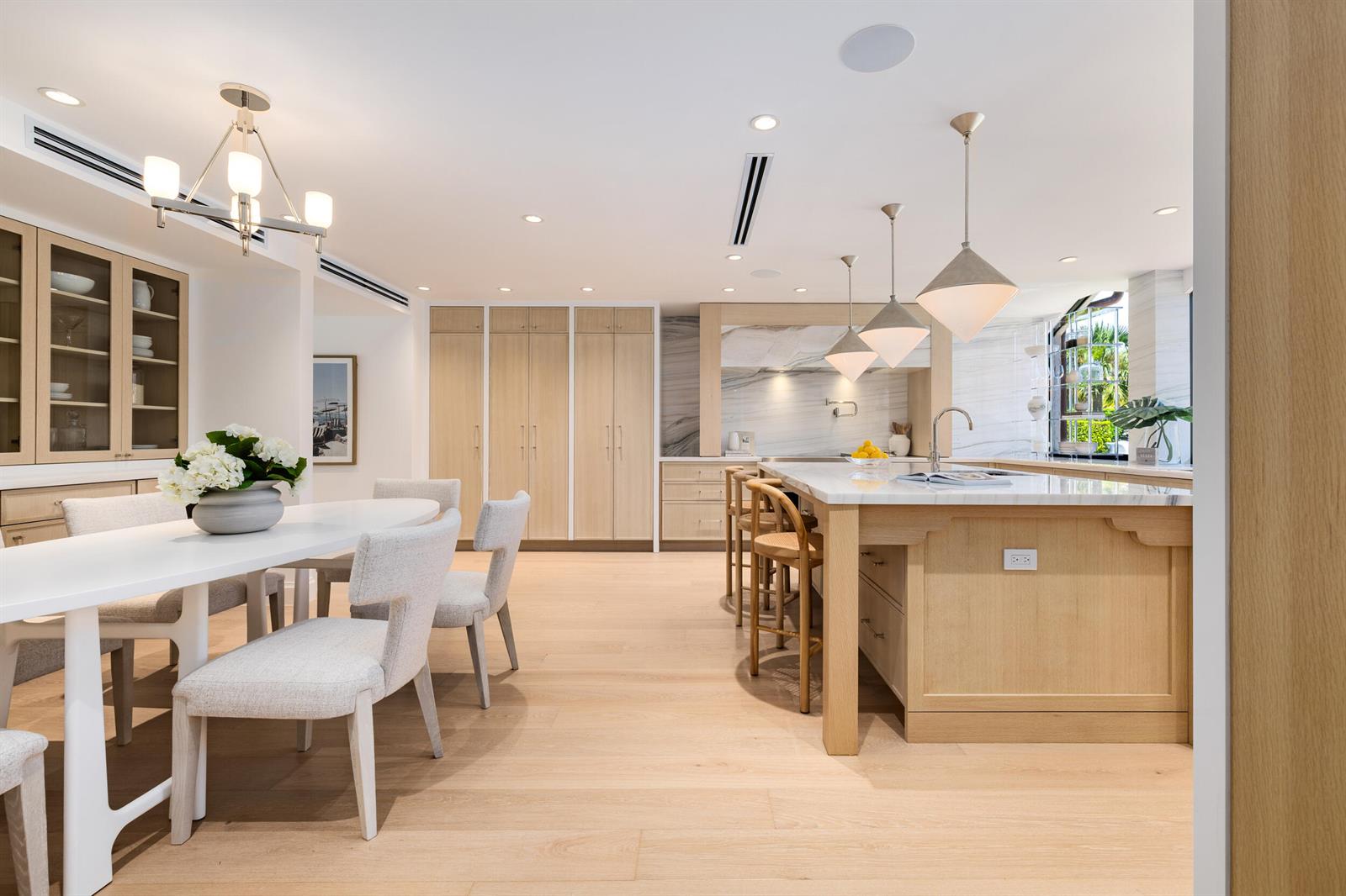 A bright, open-concept kitchen and dining area features light wood cabinetry and marble countertops — 260 Everglade Avenue, Palm Beach FL 33480, PALM BEACH, FL