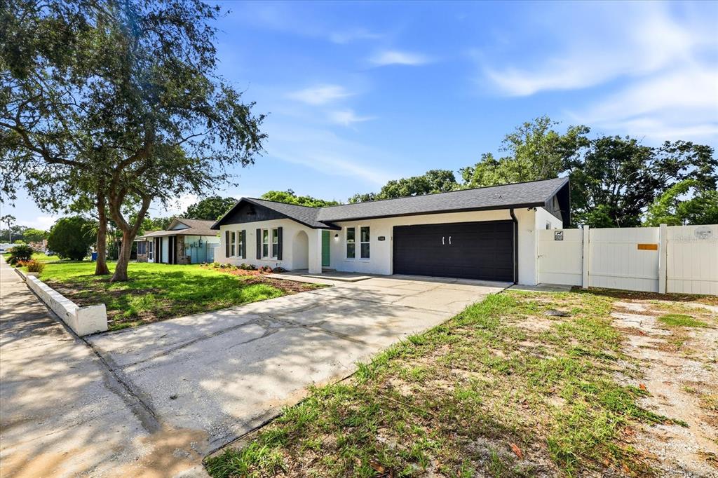 A white single-story house features a black garage door, a teal front door, and a driveway — 3304 KING RICHARD COURT, SEFFNER, FL