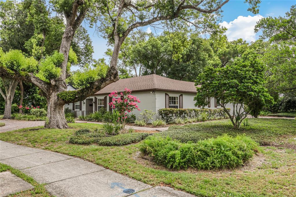 A single-story house with a brown roof sits behind a large tree and landscaped yard — 550 ARAPAHO TRAIL, MAITLAND, FL