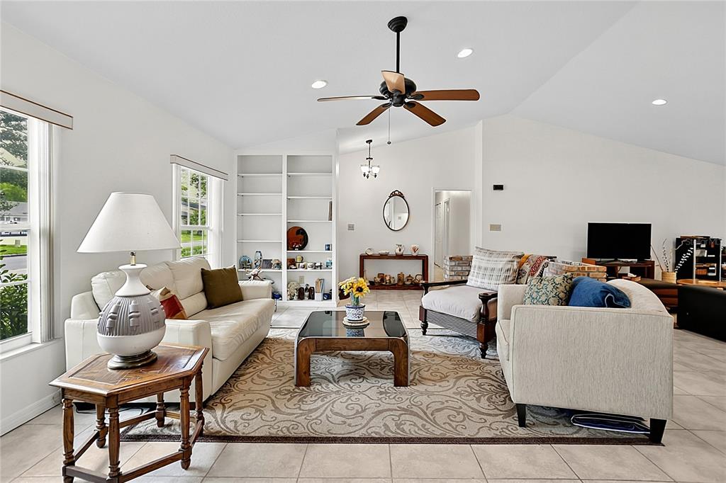A living room features a white sofa, armchairs, a coffee table, and built-in shelving — 550 ARAPAHO TRAIL, MAITLAND, FL