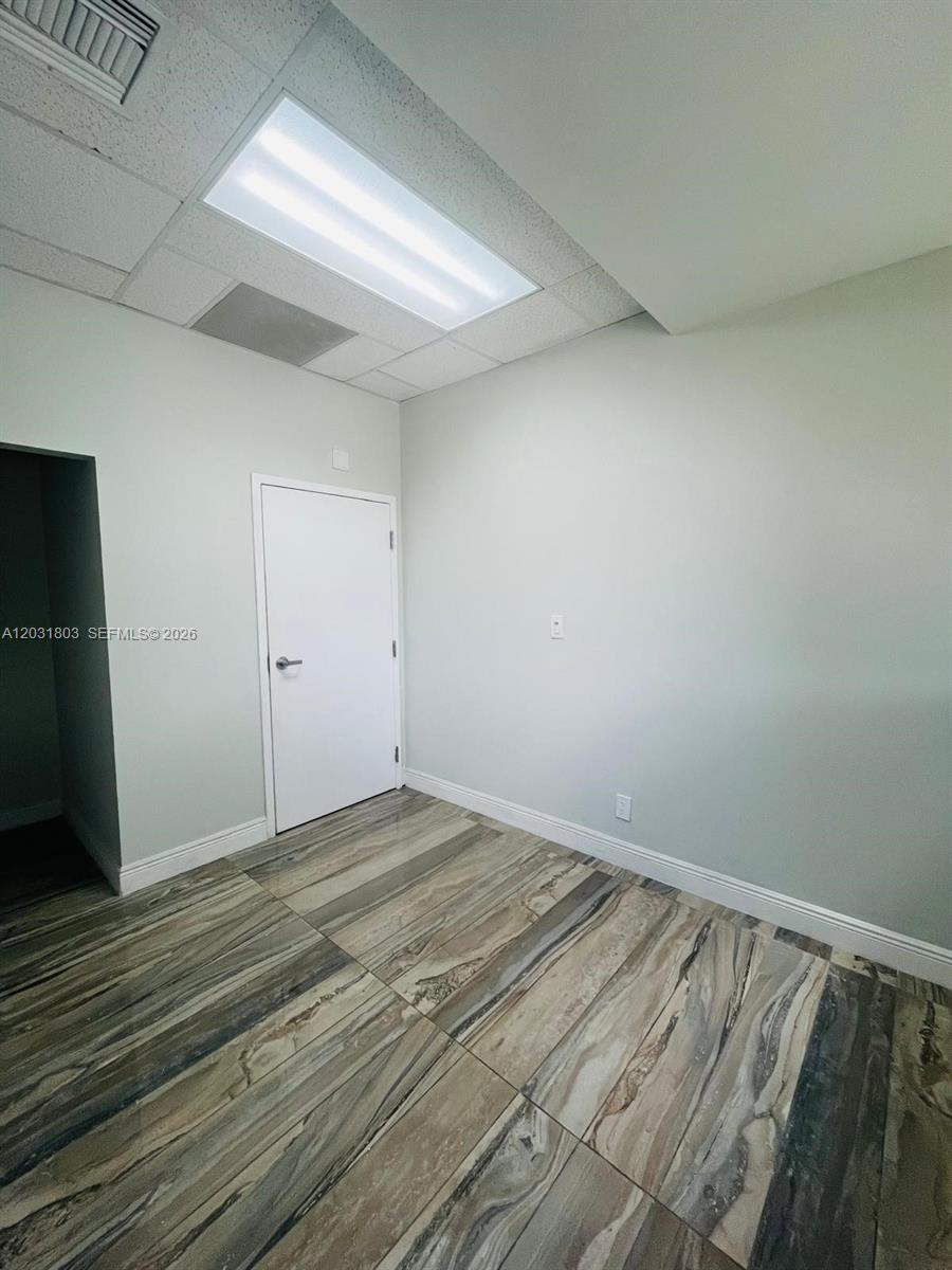 This room features light-colored walls, a drop ceiling with recessed lighting, and patterned tile flooring — 6101 W Atlantic Blvd # 205A, Margate FL 33063, MARGATE, FL