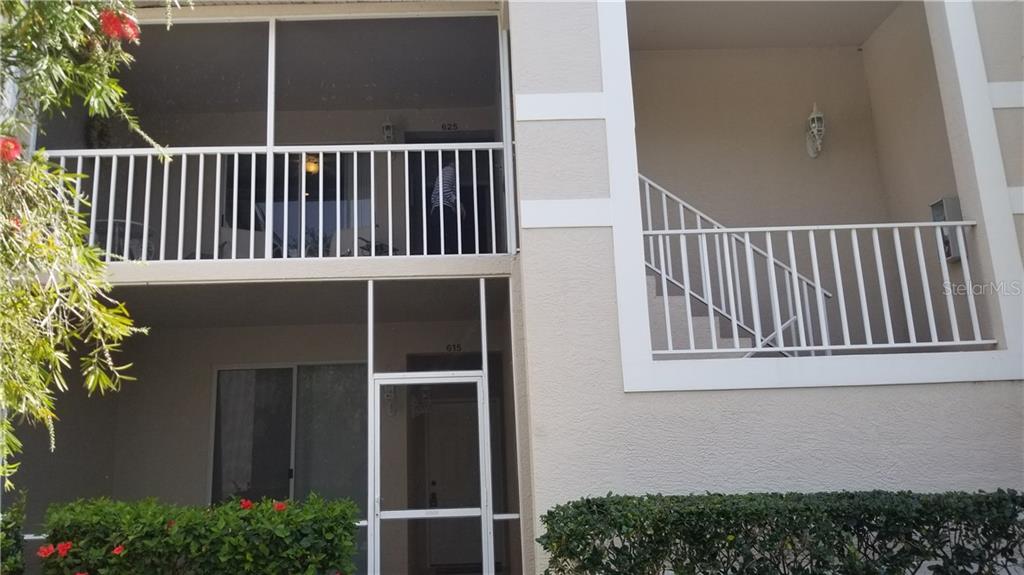 A two-story building exterior features screened balconies, white railings, and a ground-level entrance — 8951 VERANDA WAY UNIT 625, SARASOTA, FL