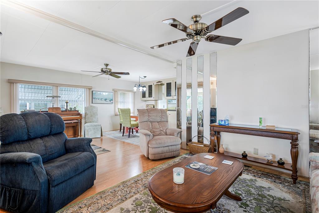 A living room with wood flooring, a ceiling fan, a recliner, and a coffee table — 3324 TIKI DRIVE, HOLIDAY, FL