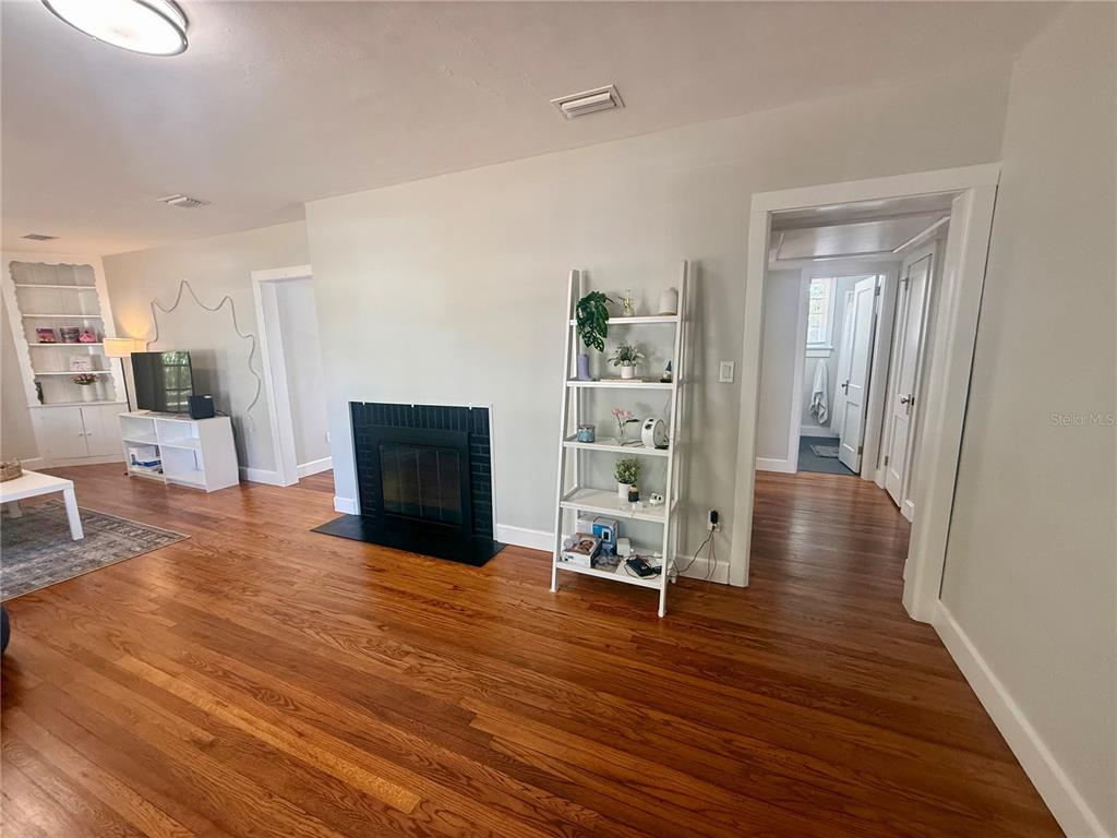 A living room features hardwood floors, a black fireplace, and a white ladder shelf — 1741 NW 6TH AVENUE, GAINESVILLE, FL